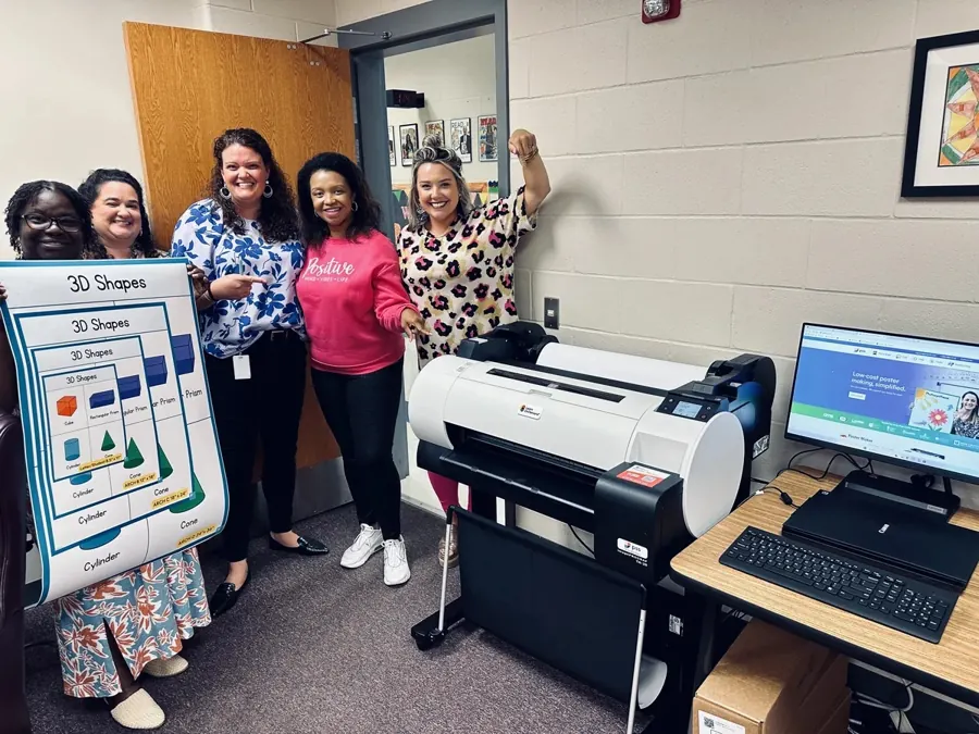 Five teachers with their PSS Poster Maker System and a 3D Shapes poster they printed in-house